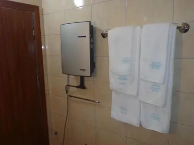 a bathroom with white towels hanging on a wall at Ski & Holiday Apartments in Pamporovo in Pamporovo