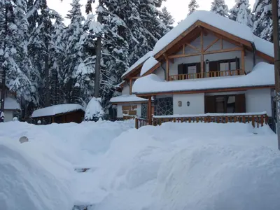 a house with a pile of snow in front of it at Saint George Holiday Village in Borovets