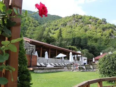 a building with chairs and umbrellas in a yard at Хотел Аква Варвара in Varvara