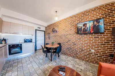 a kitchen with a brick wall and a table with chairs at Sofia Vintage Life Apartment in Sofia