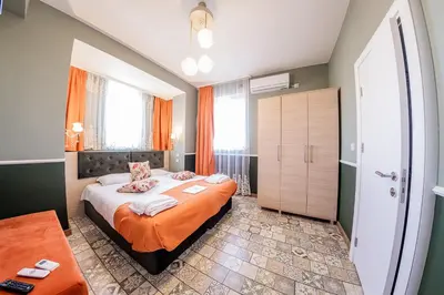 a bedroom with a large bed with an orange blanket at Sofia Vintage Life Apartment in Sofia