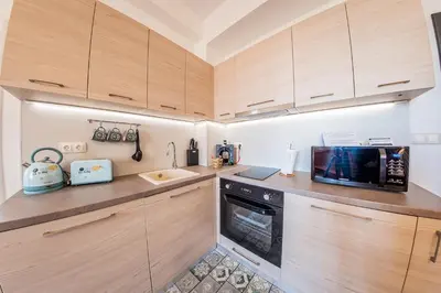 a kitchen with wooden cabinets and a microwave at Sofia Vintage Life Apartment in Sofia