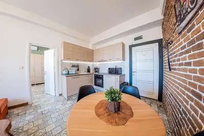 a kitchen with a wooden table and a brick wall at Sofia Vintage Life Apartment in Sofia