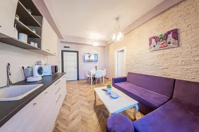 a living room with a purple couch and a table at Sofia Violet Life Apartment in Sofia