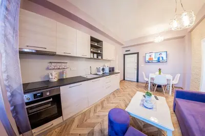 a kitchen with wooden cabinets and a table in a room at Sofia Violet Life Apartment in Sofia