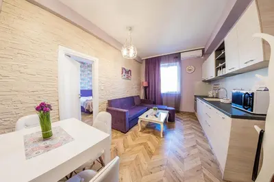 a kitchen and a living room with a couch and a table at Sofia Violet Life Apartment in Sofia