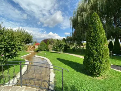 a walkway leading to a park with a tree at Yaev Family Hotel in Karlovo