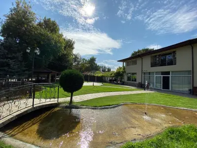 a fountain in a park next to a building at Yaev Family Hotel in Karlovo