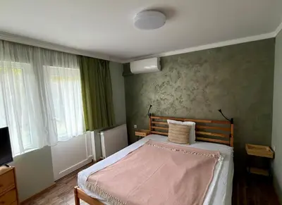 a bedroom with a bed with a pink blanket at Yaev Family Hotel in Karlovo