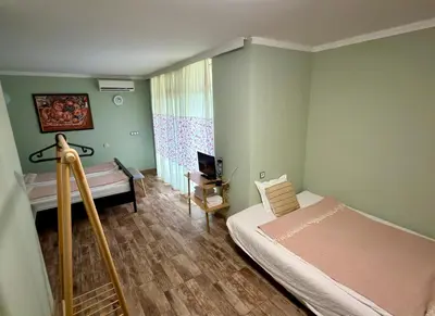 a bedroom with a bed and a desk and a television at Yaev Family Hotel in Karlovo
