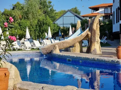 a swimming pool with a resort with chairs and a rope bridge at Wine & Spa Complex Starosel in Starosel