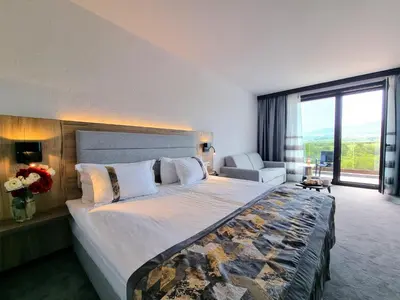 a bedroom with a large bed with a large window at Wine & Spa Complex Starosel in Starosel