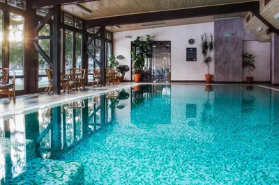 a swimming pool with blue water in a building at Ostrova Holiday Village in Beli Osŭm