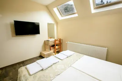 a bedroom with a bed and a flat screen tv at Апартамент Радост Сандански in Sandanski