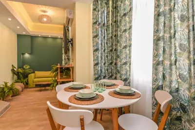 a dining room with a white table and chairs at Chic 1BR with Terrace in Sofia City Center by Flat Mаnager in Sofia