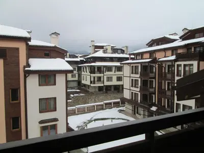 a group of buildings with snow on the roofs at Downtown Alexander Services Apartments in Bansko