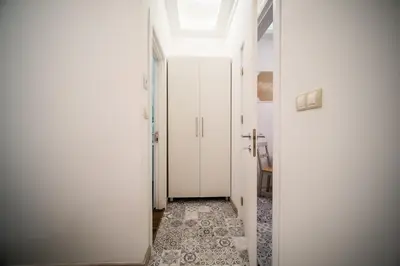 a hallway with white doors and a tile floor at Sofia Pearl Life Apartment - No Window Apartment in Sofia