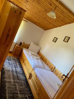 a bedroom with two beds and a wooden ceiling at вила Здравец in Yagodina