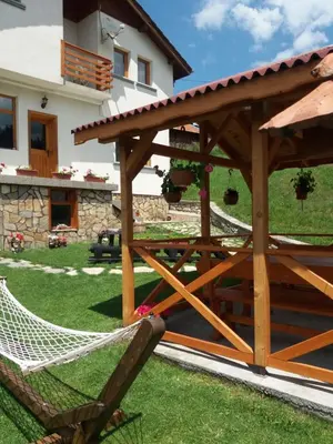 a wooden pergola and a hammock in a yard at вила Здравец in Yagodina