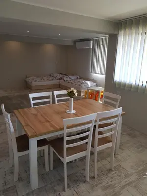 a dining room with a wooden table and chairs at United Apartments 2 in Sandanski