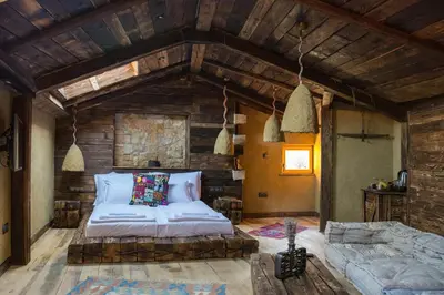 a bedroom with a large bed and a wooden wall at SABORNA 25 GUEST HOUSE in Plovdiv