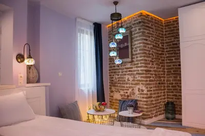 a bedroom with a brick wall and two tables at SABORNA 25 GUEST HOUSE in Plovdiv