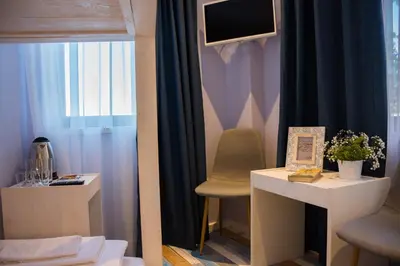 a room with a chair and a desk and a television at SABORNA 25 GUEST HOUSE in Plovdiv