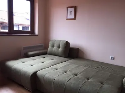 a bedroom with a bed and a chair in it at Cedar Lodge 3/4 Apartment Paradise in Bansko