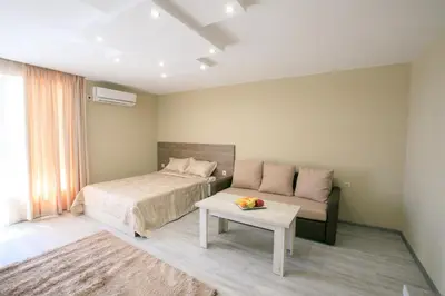 a bedroom with a bed and a couch and a table at Студиа КРИСИ in Sandanski