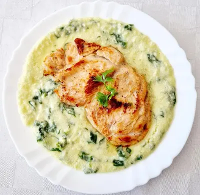 a white plate of food with shrimp and spinachowder at Motel Thessaloniki in Sandanski