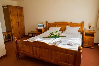 a bedroom with a large wooden bed with flowers on it at Pri Ani Guest House in Bansko