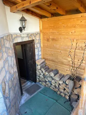 a building with a stone wall next to a door at Къща за гости Romano in Chepelare
