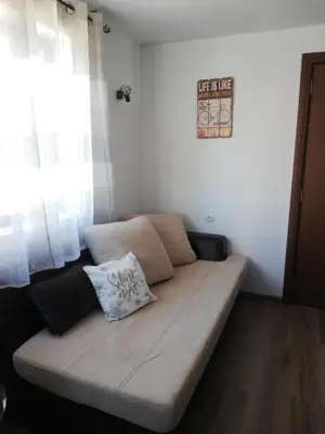 a couch sitting in a room with a window at Къща за гости Romano in Chepelare