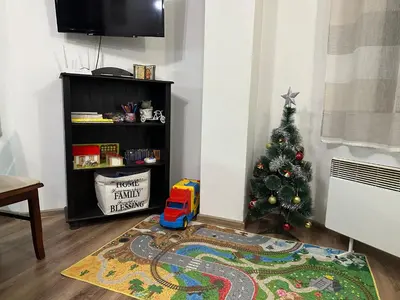 a living room with a christmas tree and a rug at Къща за гости Romano in Chepelare