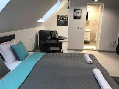 a bedroom with a large bed and a room with a bathroom at Sunpark Studios in Sandanski