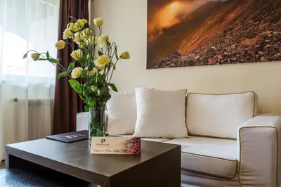 a living room with a couch and a vase of flowers on a table at Hotel Perun Lodge in Bansko