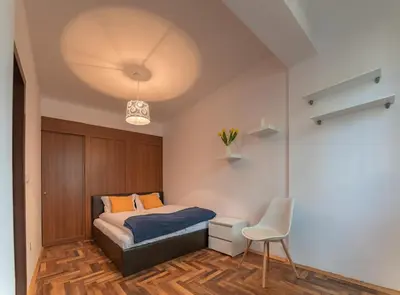 a bedroom with a bed and a white chair at Comfort.Chic.Charming Apt with Terrace near NDK in Sofia