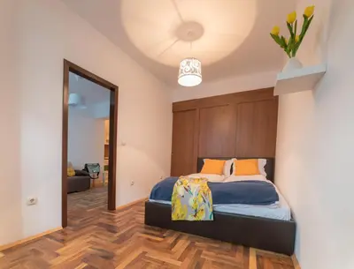 a bedroom with a bed with a wooden headboard at Comfort.Chic.Charming Apt with Terrace near NDK in Sofia