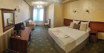 a hotel room with a large bed and a desk at Complex Praveshki Hanove in Pravets