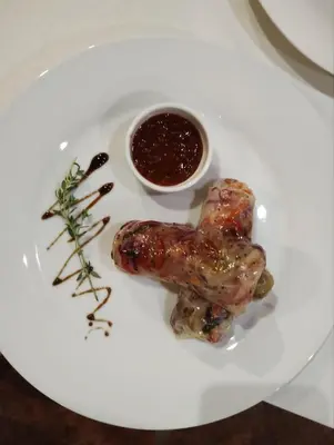 a white plate with two sausages and a sauce at Complex Praveshki Hanove in Pravets