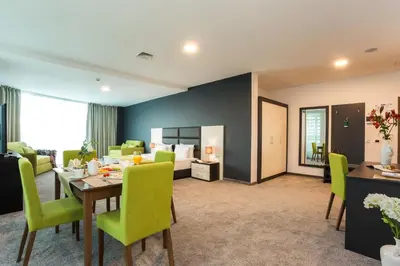 a living room with a table and green chairs at Earth & People Hotel & SPA - Free Parking & Swimming Pool in Sofia
