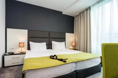a bedroom with a large bed with a yellow blanket at Earth & People Hotel & SPA - Free Parking & Swimming Pool in Sofia