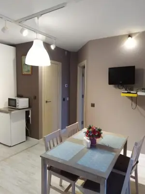 a dining room with a table and chairs and a television at A-Apartment in Krasnovo