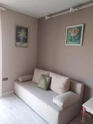 a white couch in a room with two pictures on the wall at A-Apartment in Krasnovo