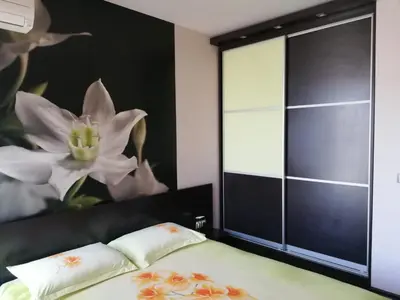 a bedroom with a bed and a large window at Апартамент Мегилукс in Blagoevgrad