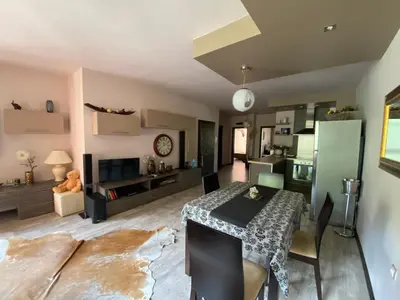 a living room with a table and a kitchen at Апартамент Мегилукс in Blagoevgrad
