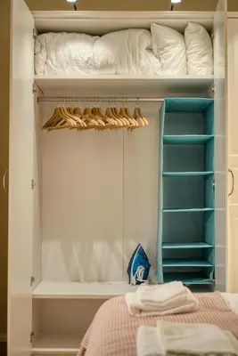 a closet with blue shelves and a bed at Apartment Audrey by SofiaSpot - central, metro to airport in Sofia