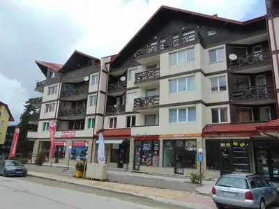 a building on a street with cars parked in front of it at IGLIKA 2 SNOWY NIGHT V18 in Borovets