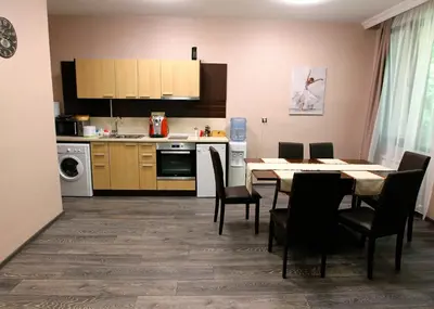 a kitchen and dining room with a table and chairs at NIKI Apart in Sofia