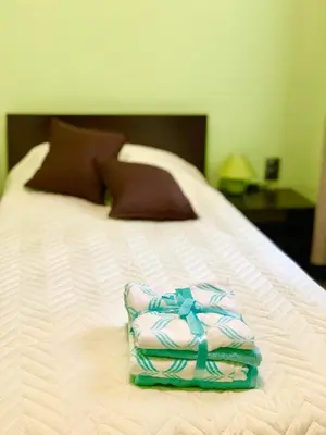 a white bed with a box on top of it at NIKI Apart in Sofia